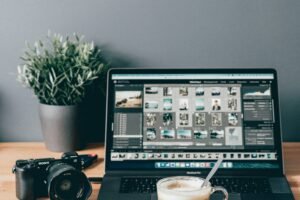 black laptop computer beside white ceramic mug on brown wooden table